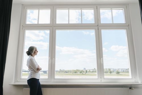 Frau blickt aus einem Fenster